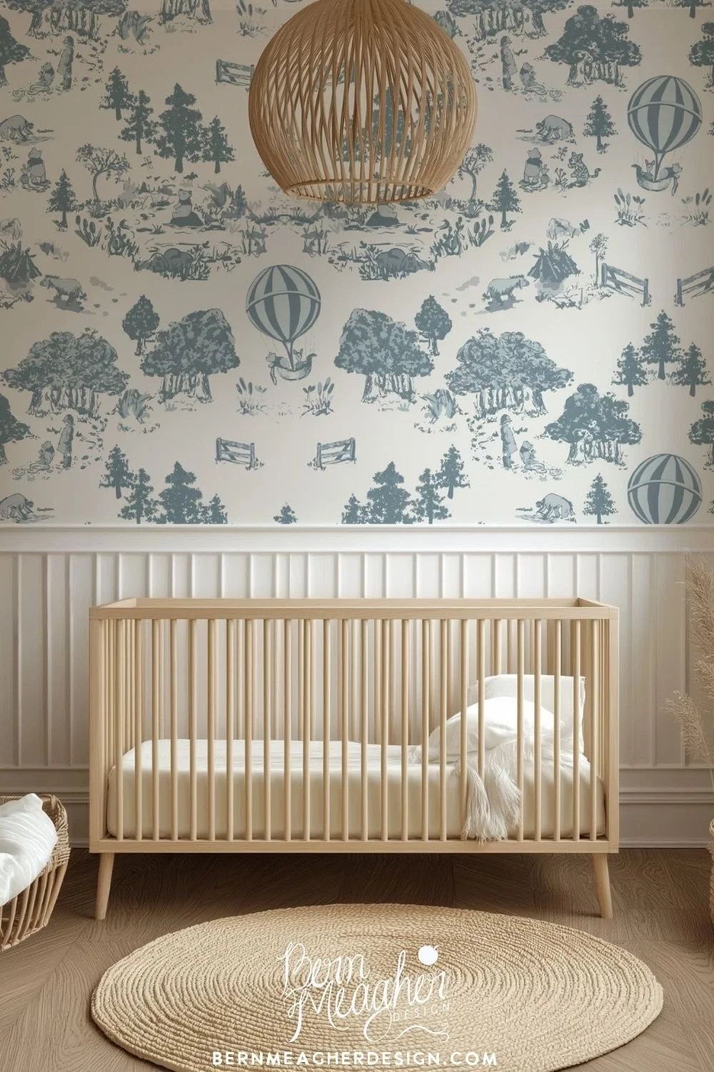 Peel & stick wallpaper in soft blue and cream with detailed nature illustrations including trees, animals, and hot air balloons, styled in a nursery with natural wood crib, woven basket, pampas grass, and a round woven rug.