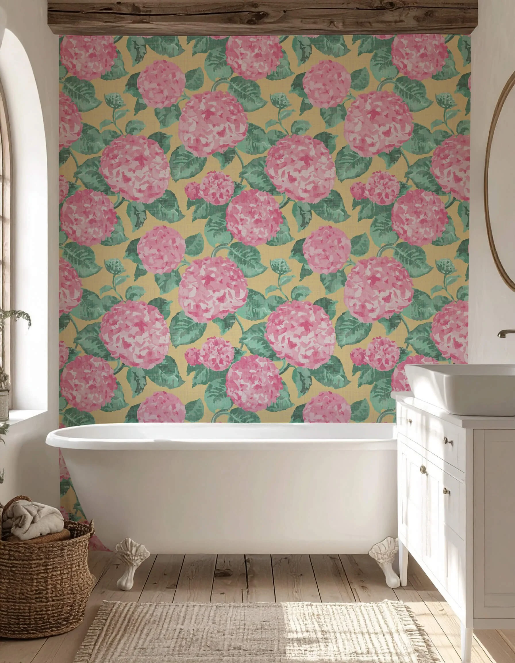 Farmhouse Bathroom with large floral pink hydrangea wallpaper behind a white clawfoot bathtub, wooden floor, beige rug, and white vanity.