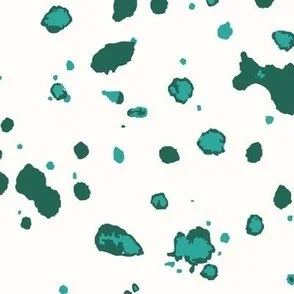 Loose, inky splashes and dots in muted jade and dark emerald green are scattered across a warm cream ground, creating an abstract, organic, allover “ink splatter” look that feels modern, airy, and stone-like.