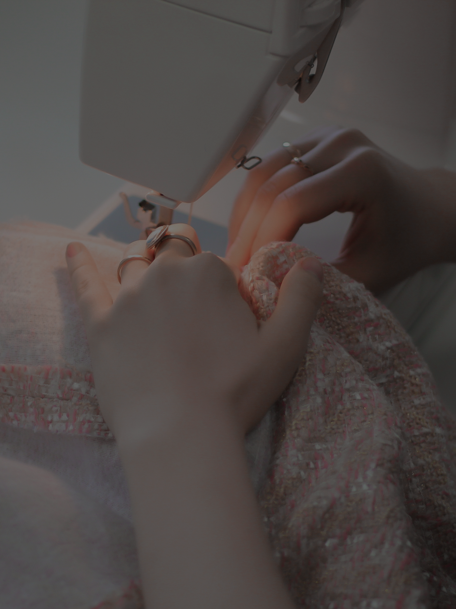 Person sewing pink fabric with sewing machine