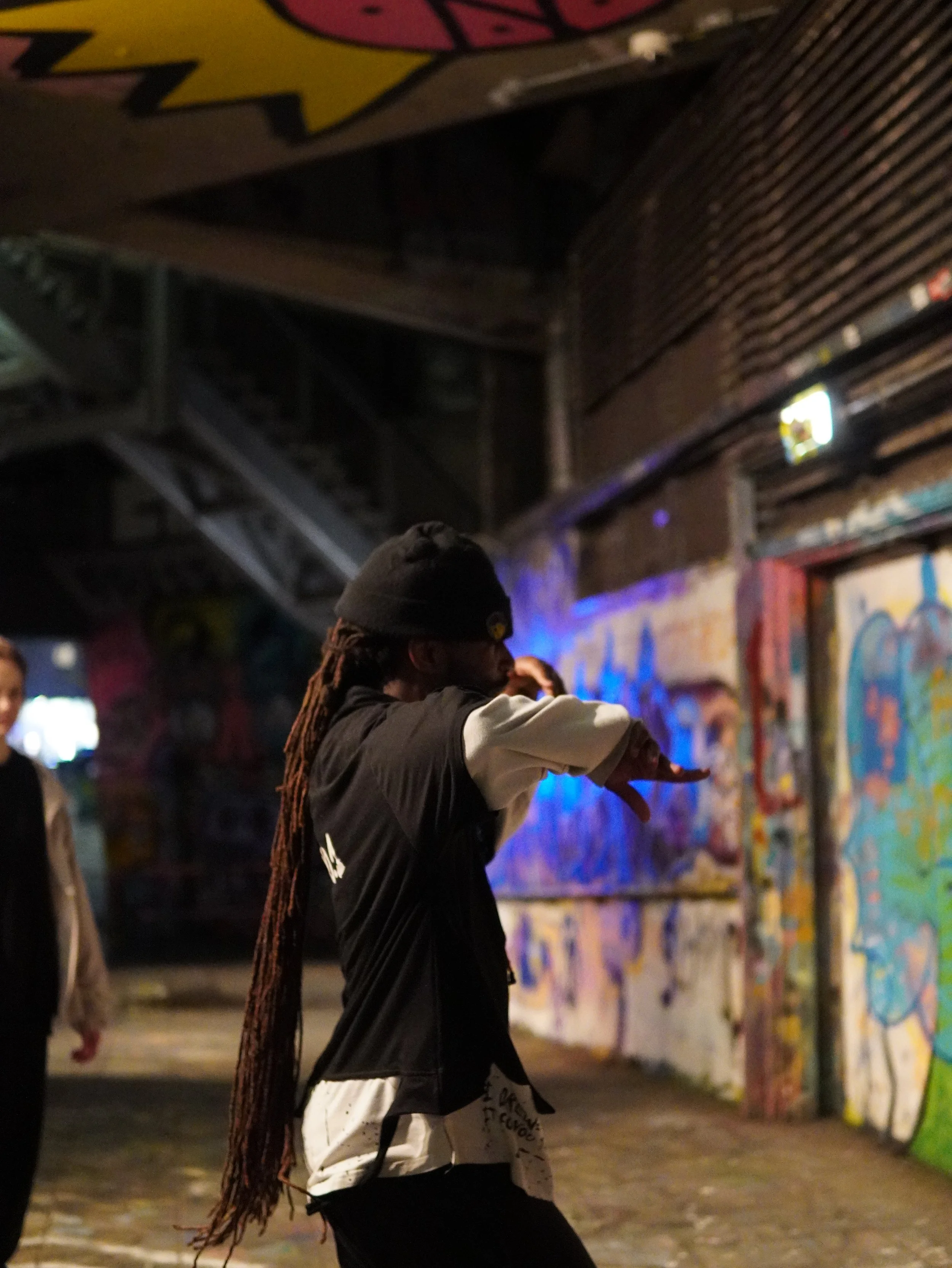 Street dancer practising beside a graffiti-covered wall