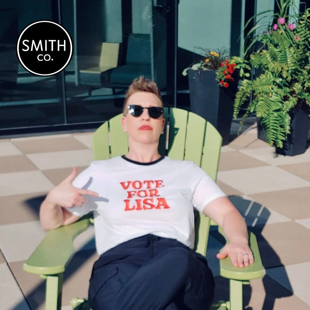 Lisa Smith, the premier Sales Coach for Female Executives & Business Owners, sitting on a green chair.