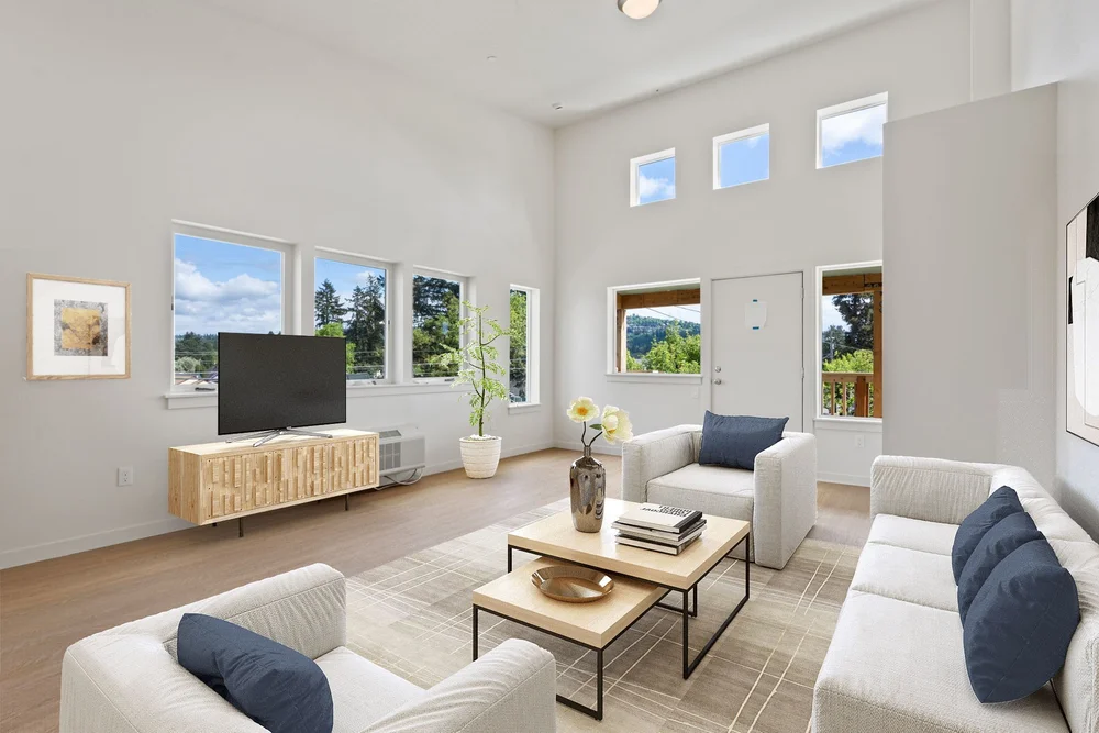 Sunlit living room with vaulted ceiling and a wall of windows