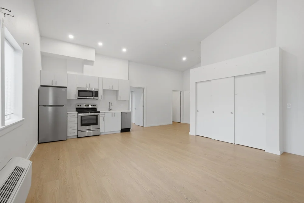 Open kitchen with stainless appliances and wood floors