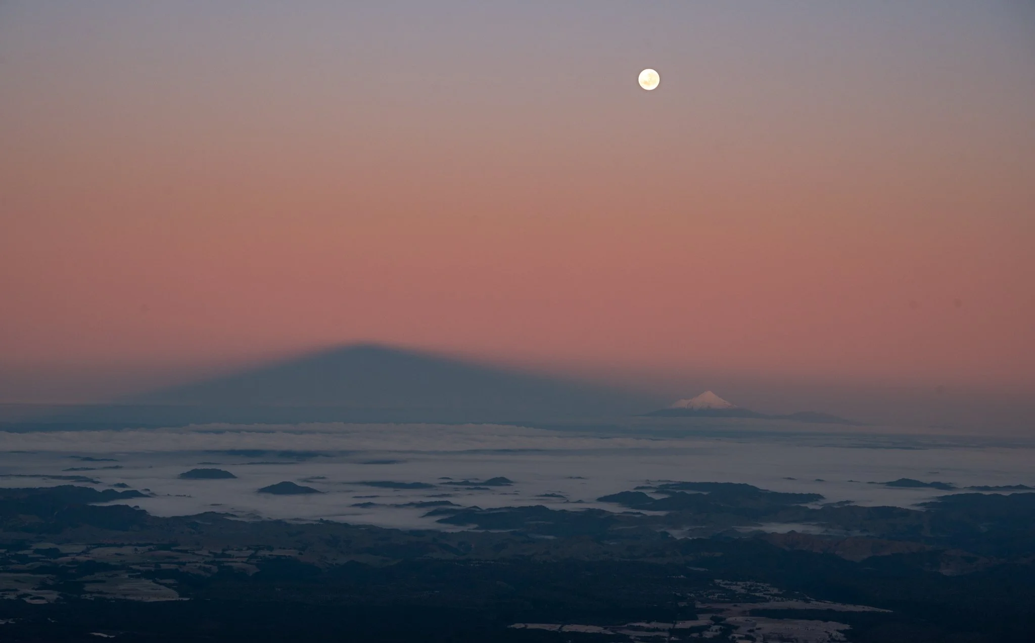 Shadow of Mount Ruapehu cast next to Mount Taranaki over 100km away.