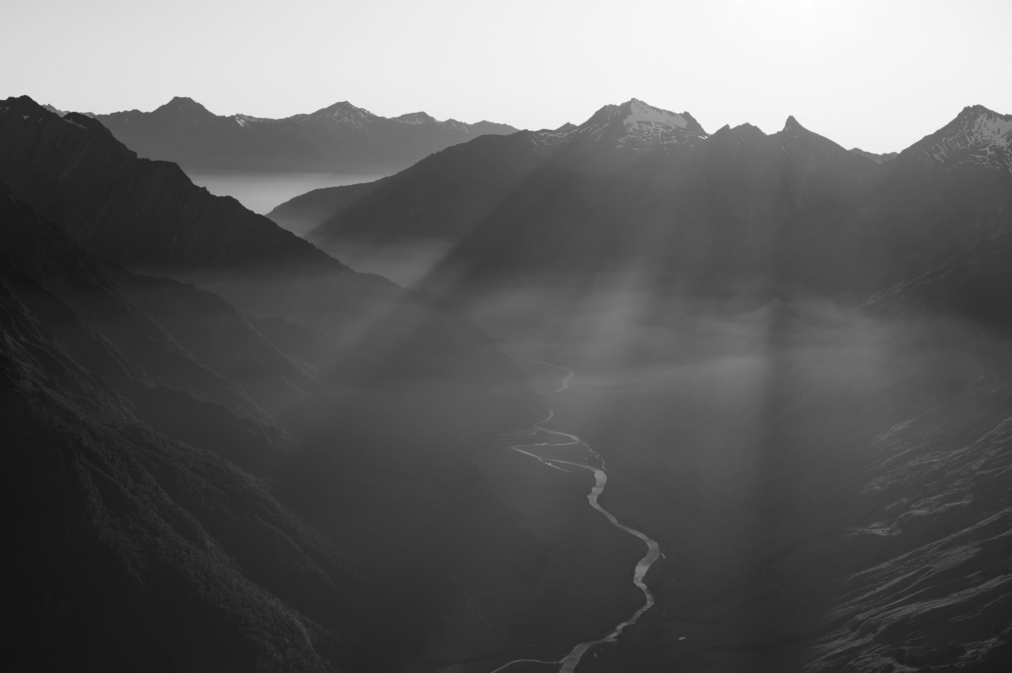 Mist and first sun rays over Matuki River and its valley, Aspiring National Park.