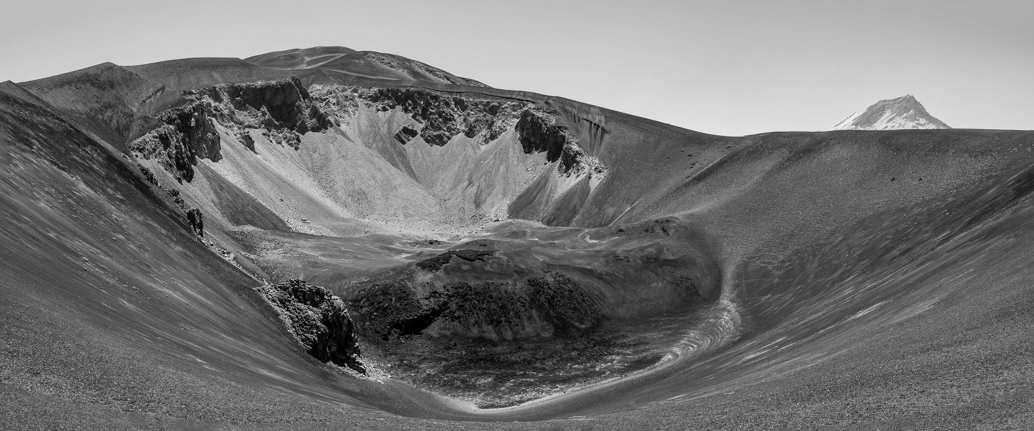 Peaking into the crater of Los Quillayes with the top of Volcan Descabezado Grande in the background.