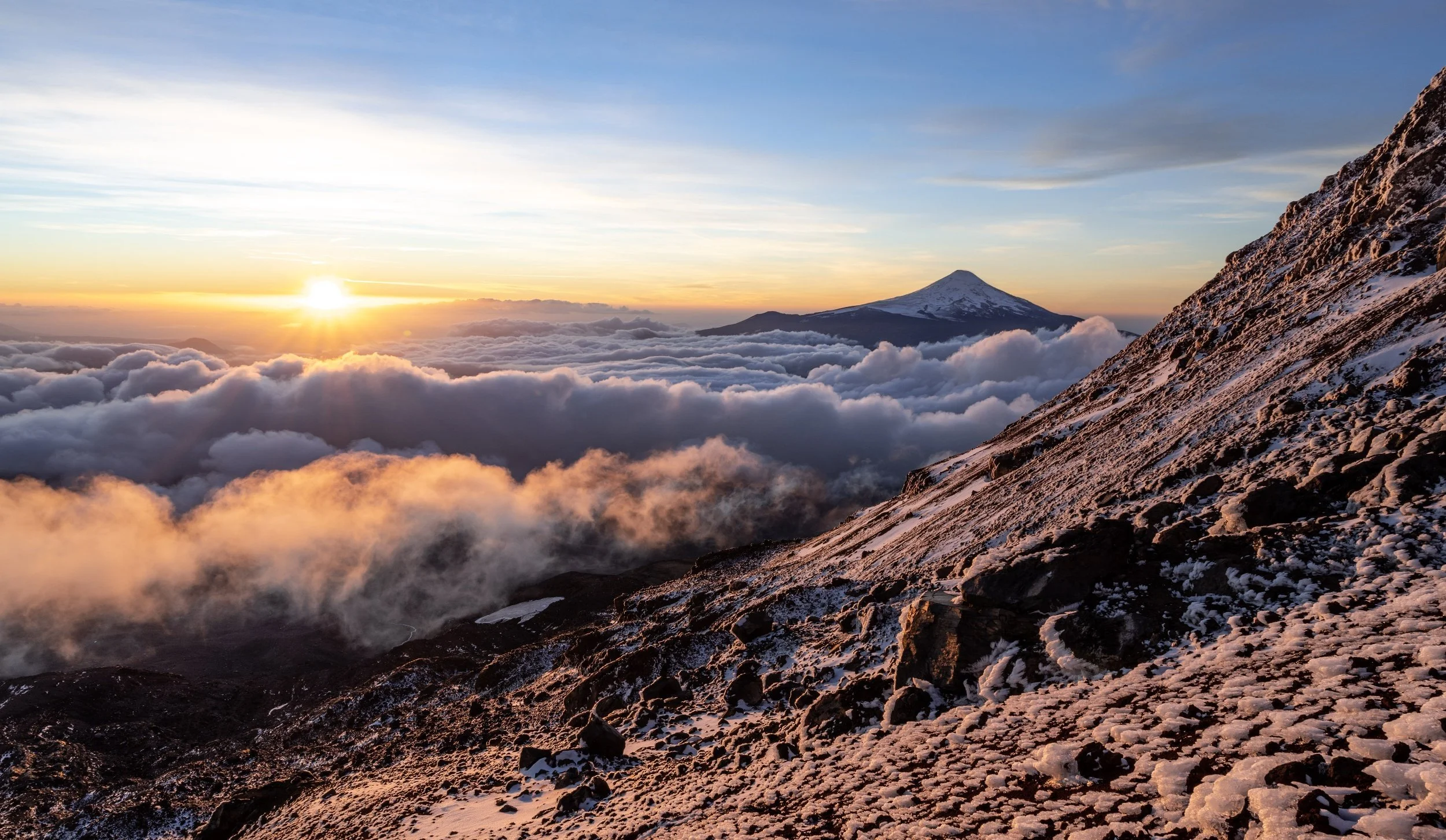 Until the landscape opened up completely around us, revealing a jaw-dropping sunset and 360° views of the surrounding volcanoes. In the distance was Villarrica, one of the most active, famous, and frequently climbed volcanoes in Chile.
