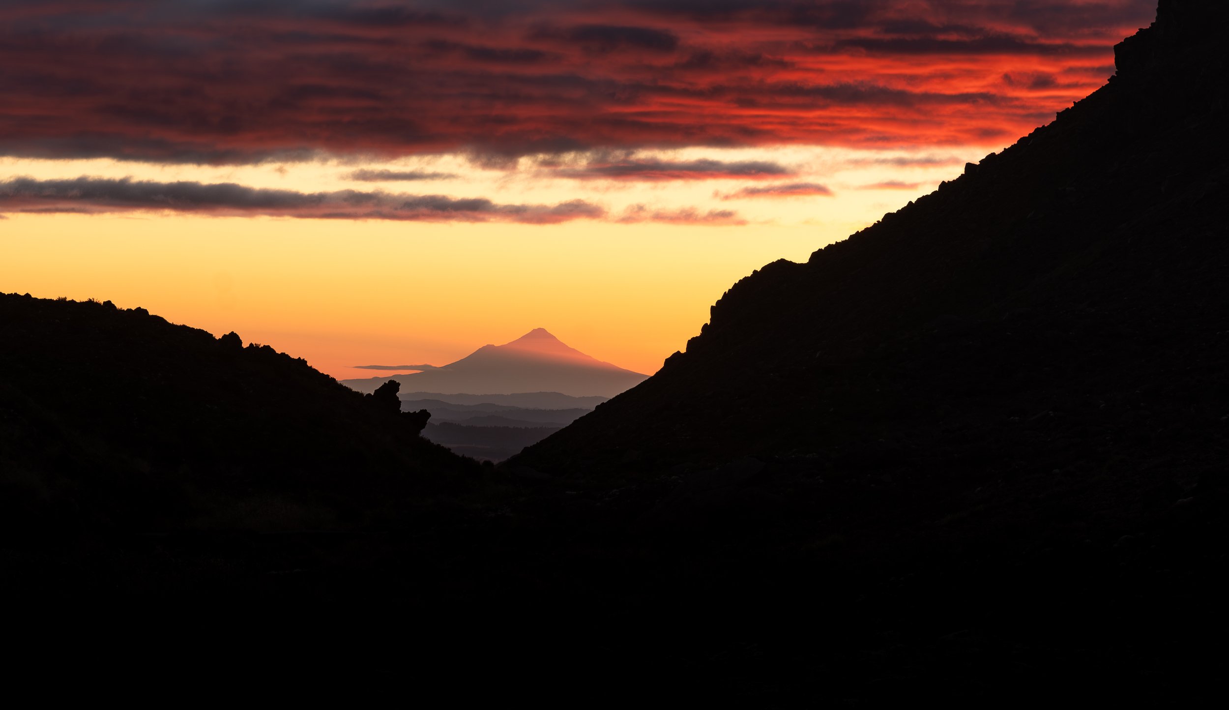 Taranaki Maunga at sunset photographed over a hundred kilometres to the east from the Tongrariro Crossing. 