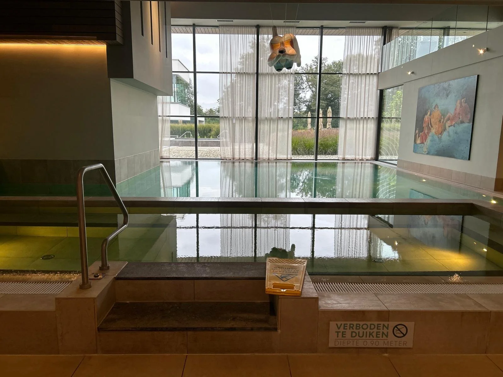 Uitzicht van onderaf op een hoog gebouw met een Media Markt winkel op de begane grond, fietsen geparkeerd voor de ingang en een blauwe lucht met enkele wolken erboven.