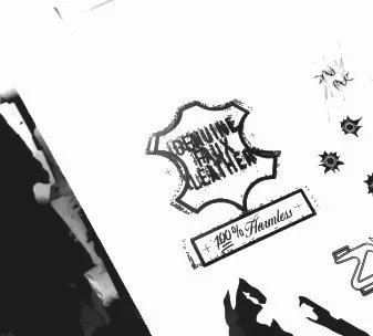 Sketch of a stylized leather emblem with the text "Genuine Faux Leather - 100% Harmless" along with some decorative elements and partially visible designs. Daniel Alexander Weiter - DAW
