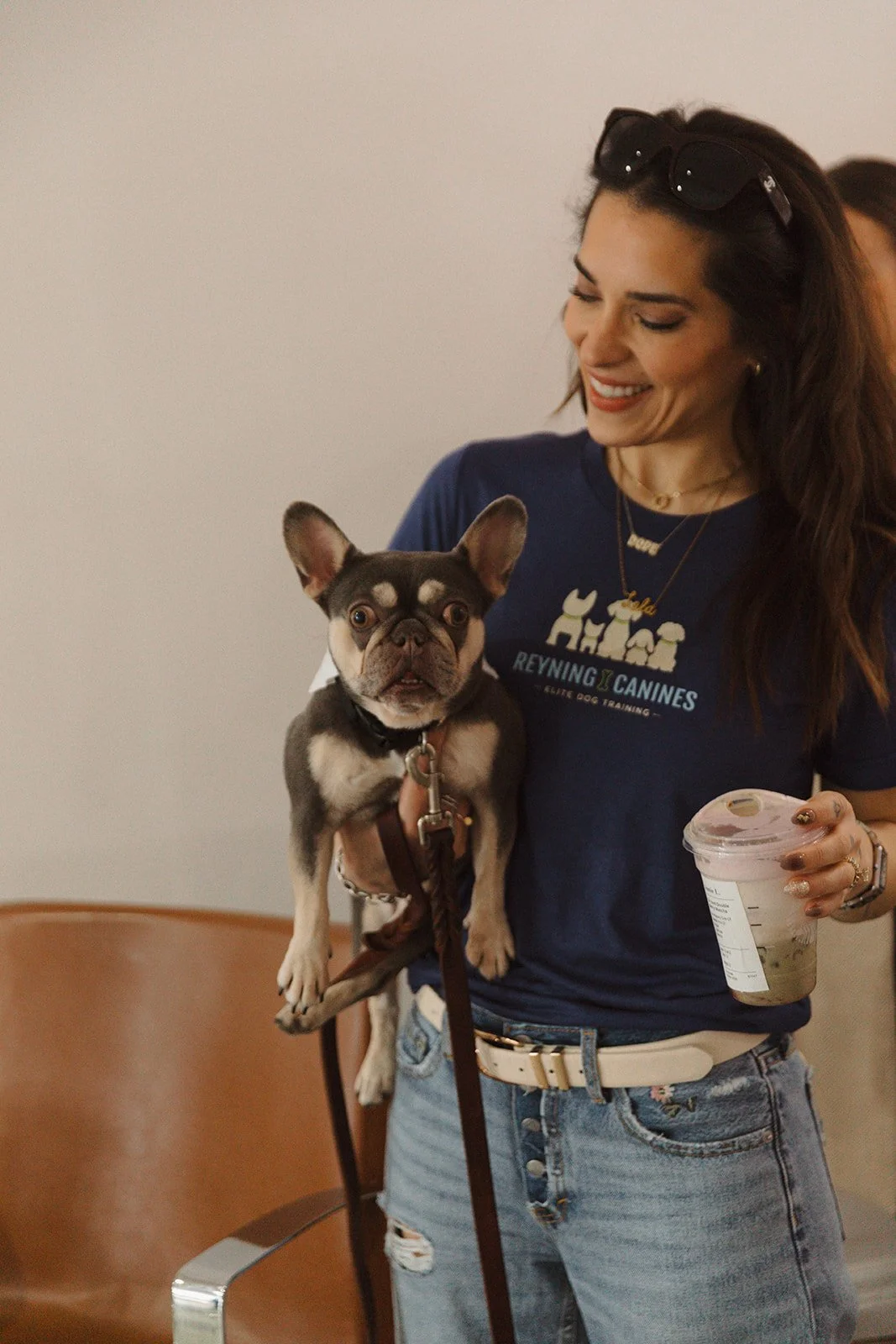 A woman and her well trained dog smiling. Dog is on good behavior, no barking, no pulling, and listening to commands. Dog is well behaved indoors.
