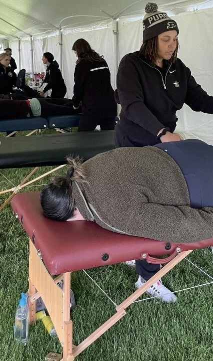 Training at Indiana Therapeutic Massage School — practicing assisted stretch techniques to support movement, recovery, and care for Mini Marathon participants.