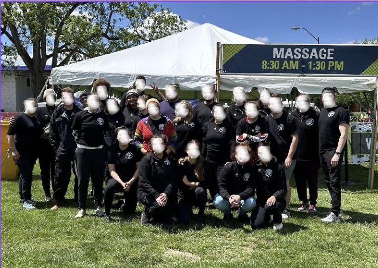 A group moment with Indiana Therapeutic Massage School students and alumni after supporting Mini Marathon participants through post-event stretching and recovery.