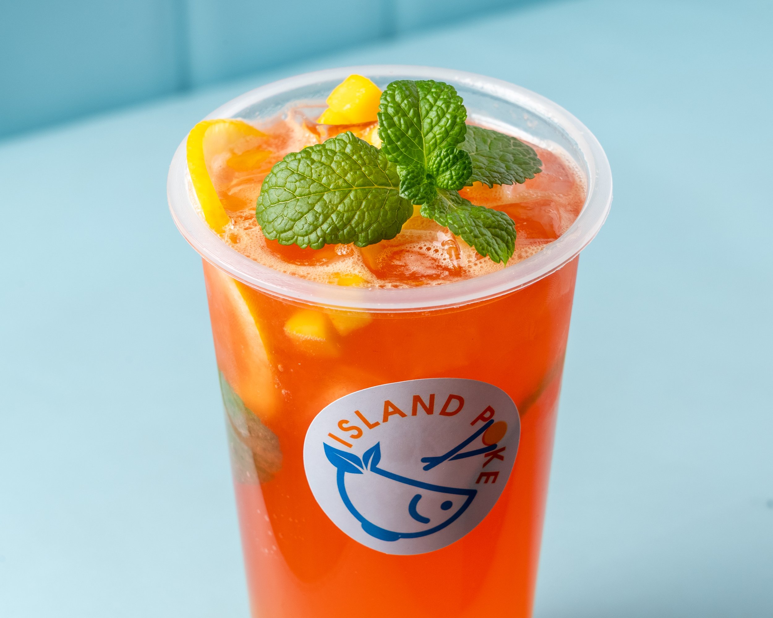 Island Poke strawberry mango tea boba with fresh fruit mangos, lemon, oranges, and mint, served chilled in Milford, CT.