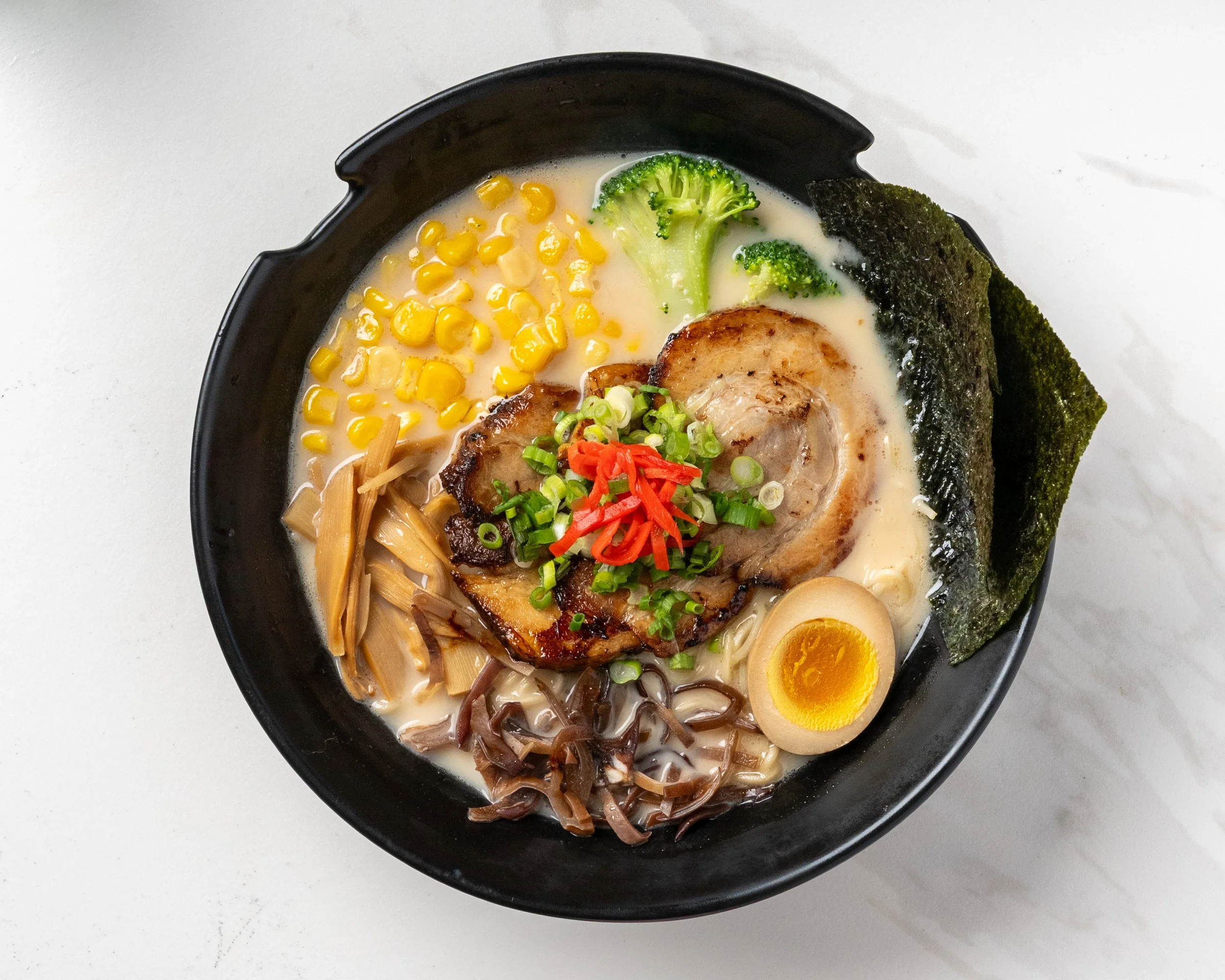 Island Poke tonkotsu ramen featuring rich pork broth, sliced chashu pork, soft-boiled egg, corn, mushrooms, and noodles, served fresh in Milford, CT.