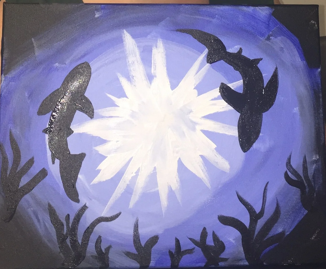 silhouette of sharks circling in the ocean