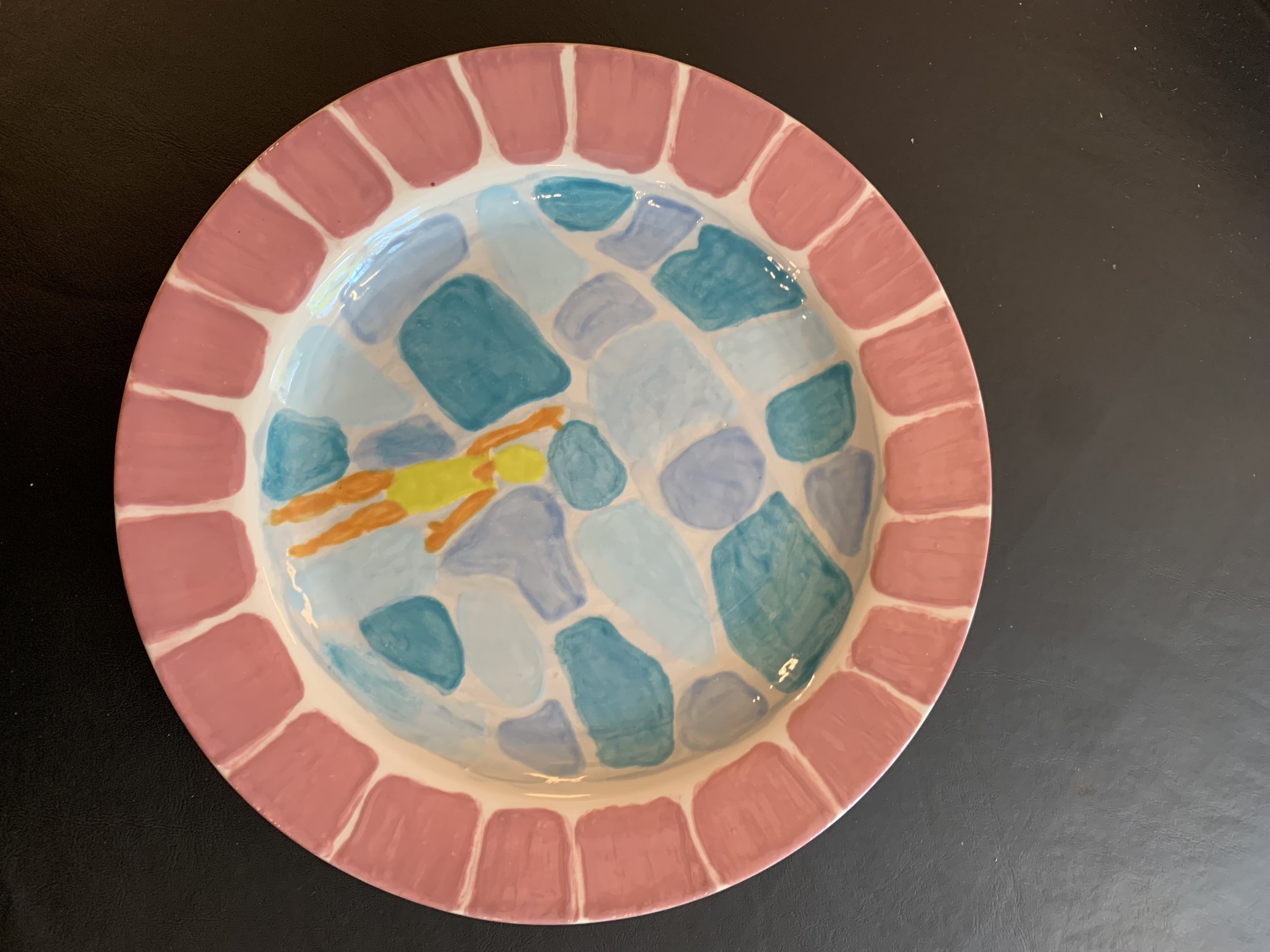 ceramic plate with mosaic deign of someone swimming in a pool