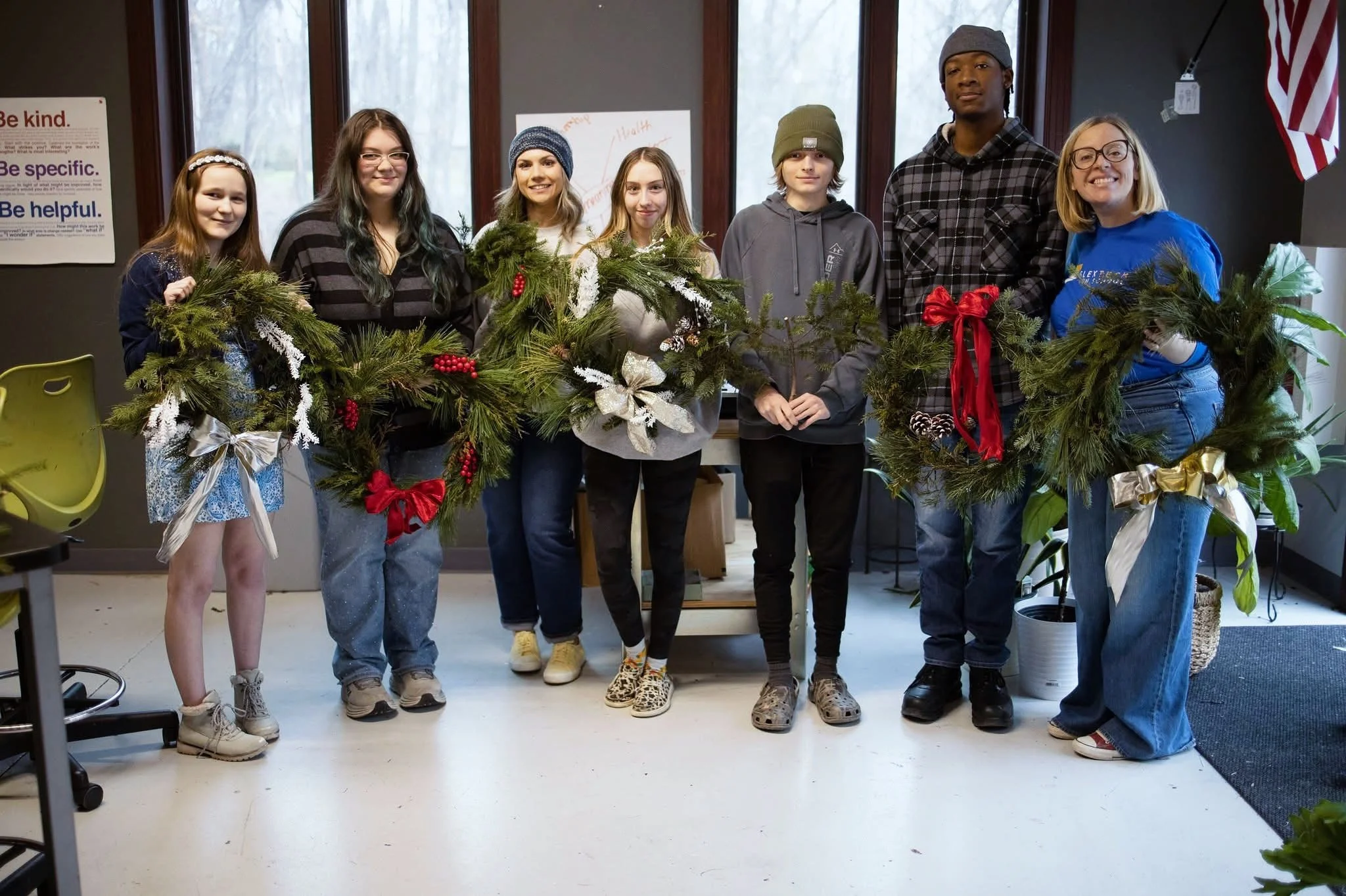 Seven young high school students standing together at a project-based learning high school in Brighton, MI.