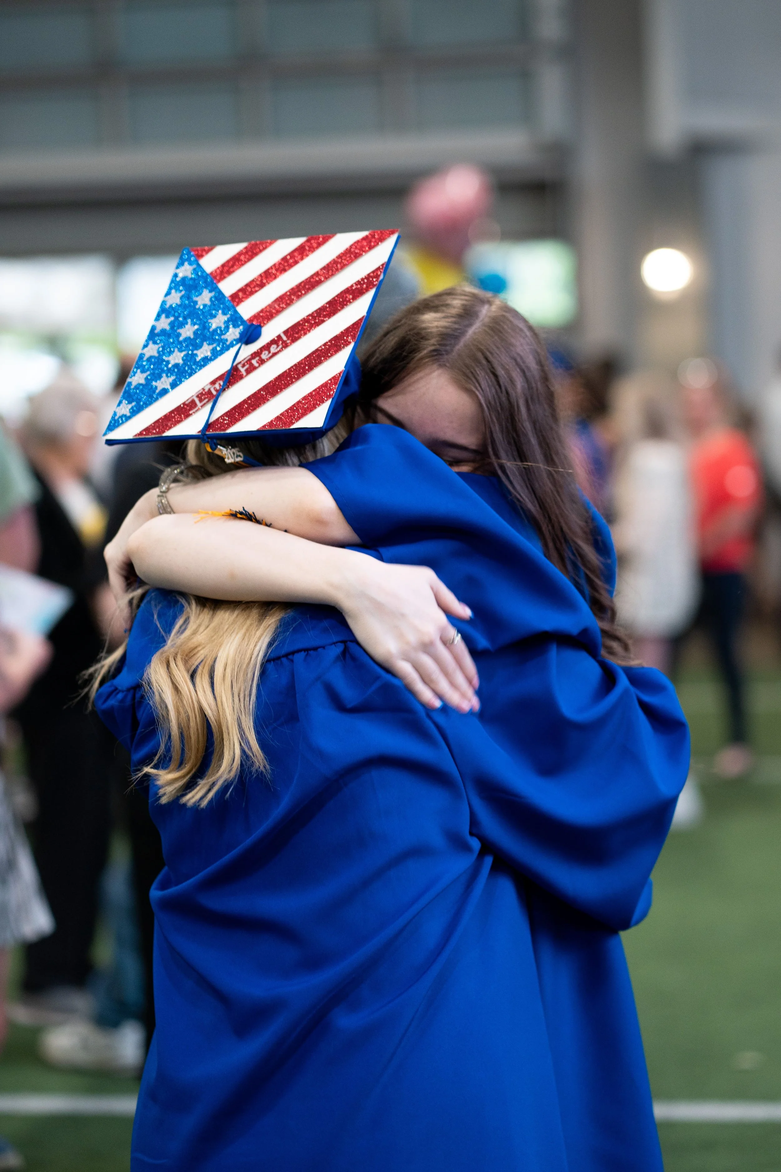 Two FlexTech Brighton graduates hugging at commencement, celebrating the supportive community and personalized high school experience