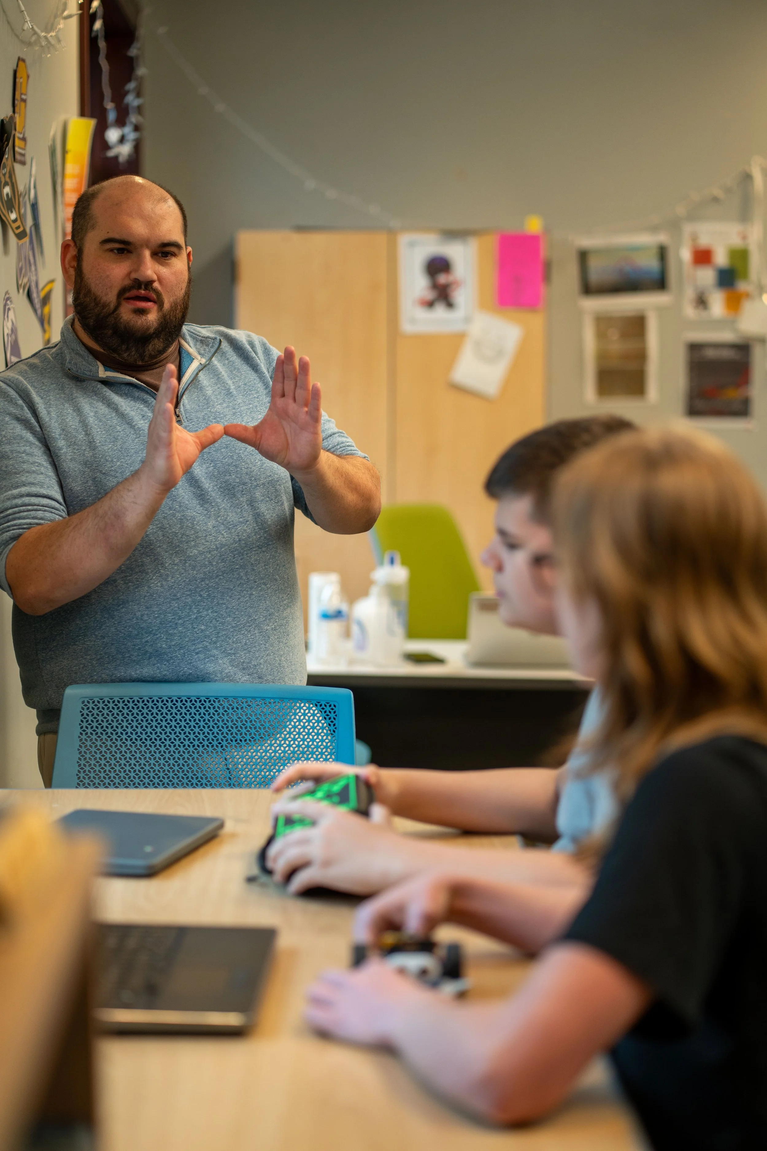 high school teacher using personalized learning methods to teach classroom of high school students.