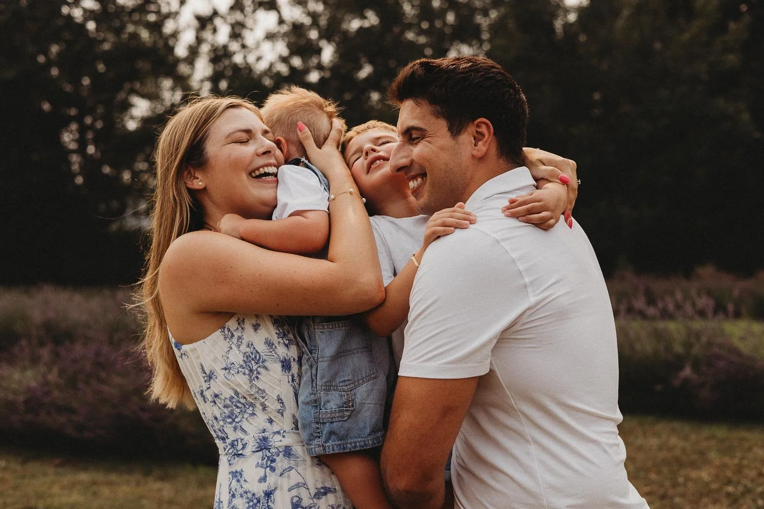 Mom, dad and boys hugging and smiling while an outdoor family photoshoot in La Maison Lavande, St-Eustaceh