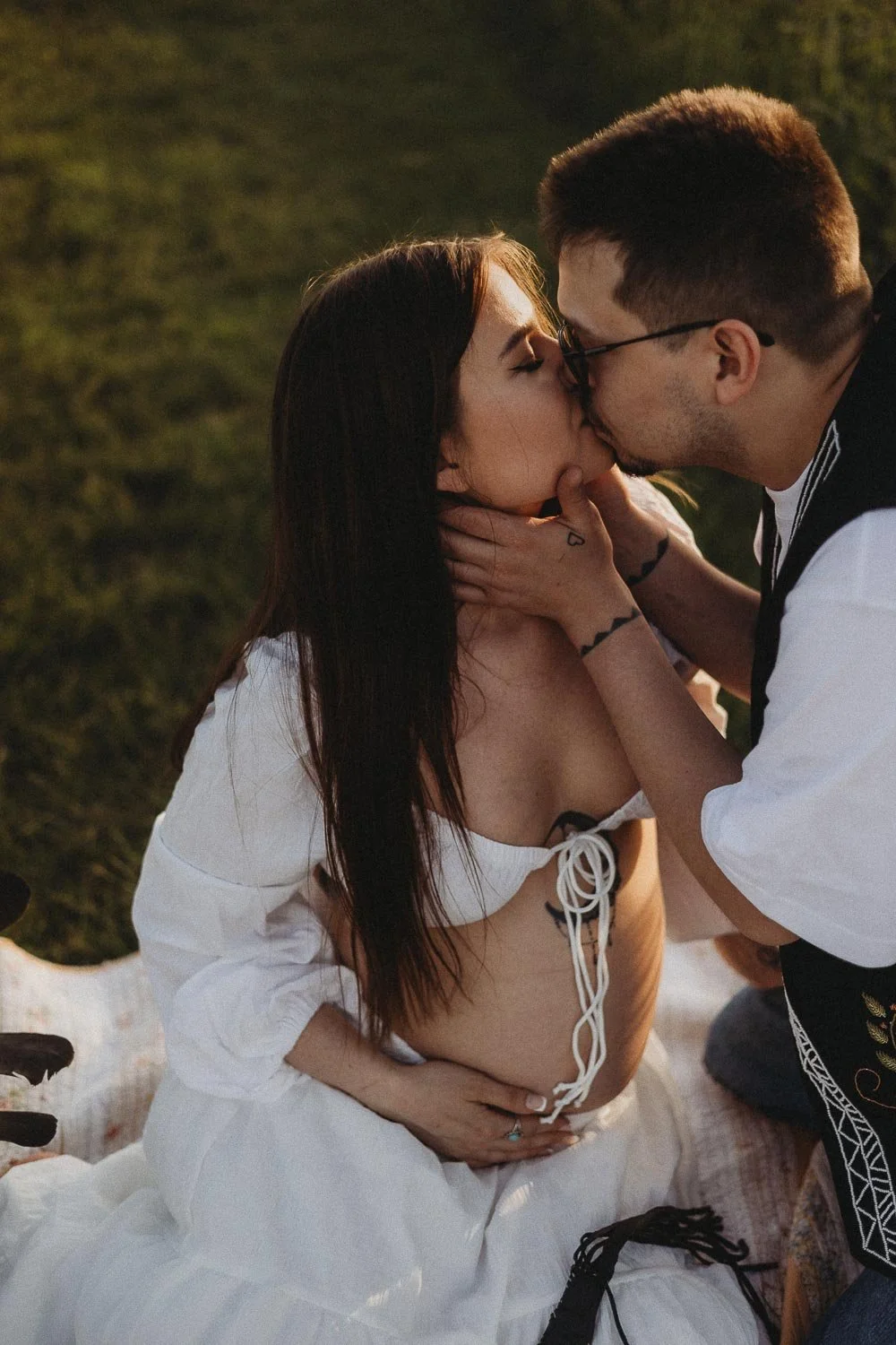 A couple gently kissing during an outdoor maternity photo session during golden hour in Boucherville Island