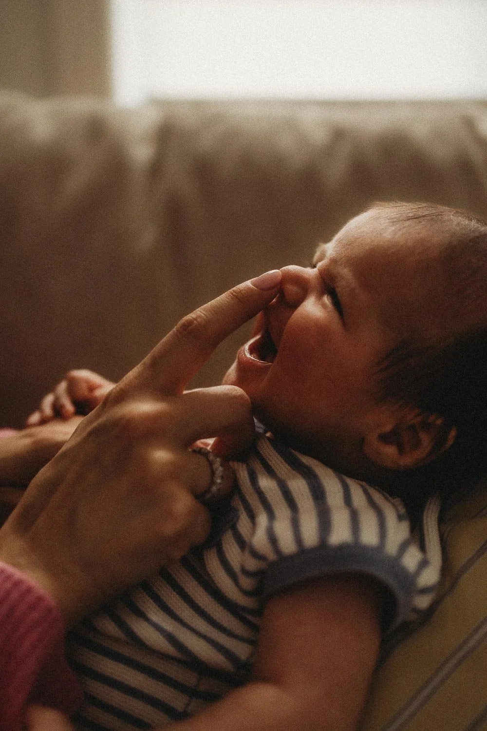 A closed-up photo of a baby being tickled on the nose by his mom captured during an in-home newborn photoshoot in Hampstead, Montreal