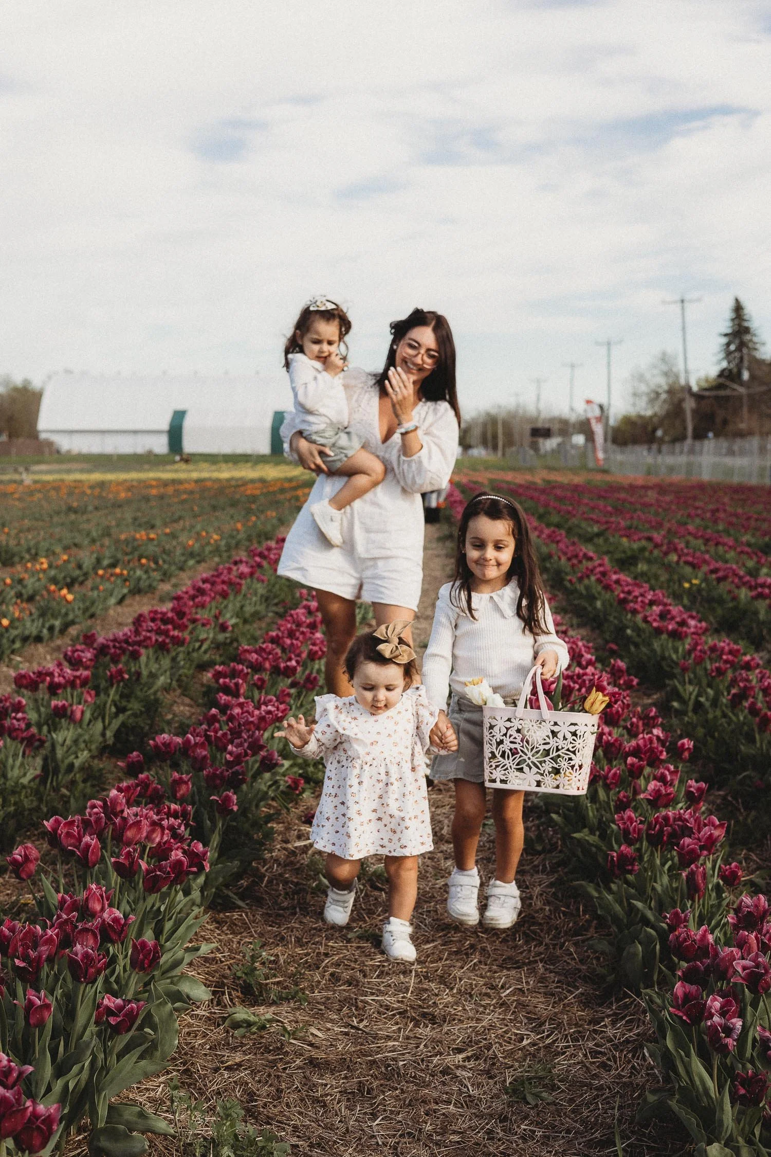 Mom and daughters walking around the tulips fields in Laval, Quebec.