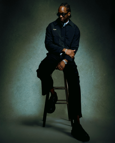 Jon Onabowu seated at bar stool with sunglasses