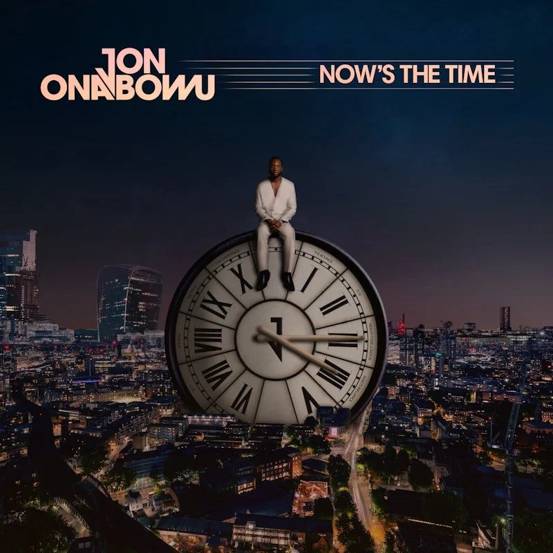 Jon Onabowu sitting on a clock with the London skyline