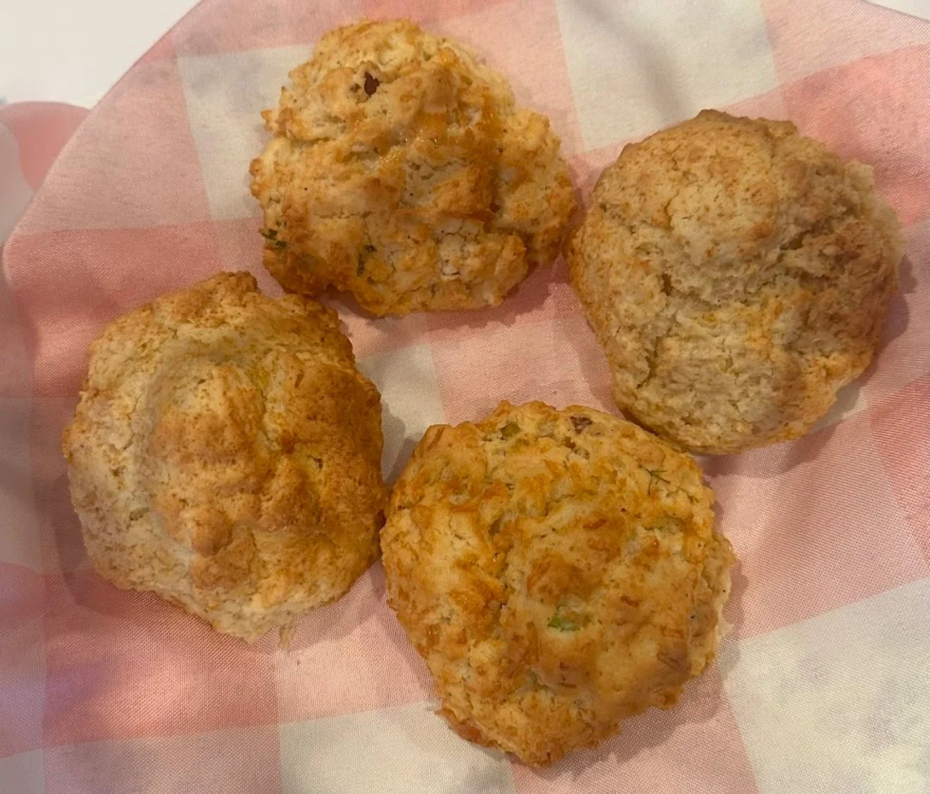 Four savory muffins on a pink checkered napkin.