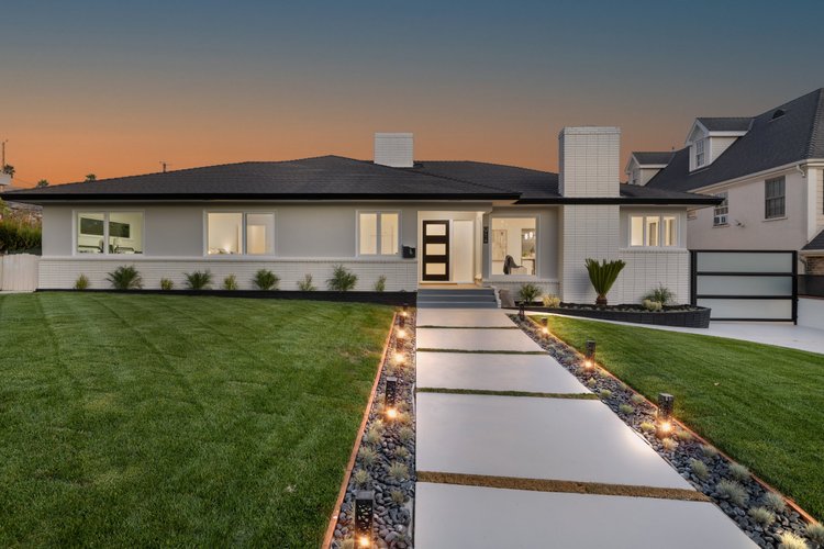Modern home at dusk with lit pathway