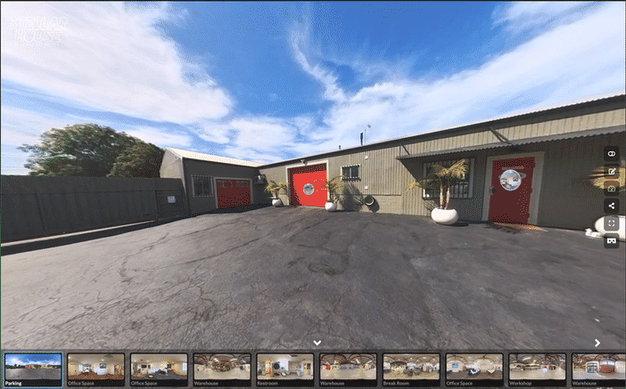 Modern kitchen with white marble countertops, gray cabinets, stainless steel appliances, and pendant lights.