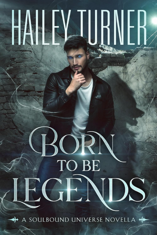 Book cover for 'Born to Be Legends' by Hailey Turner featuring a man with dark hair and a beard wearing a black leather jacket and a white shirt, standing in front of a mysterious, dark background with faint light effects.