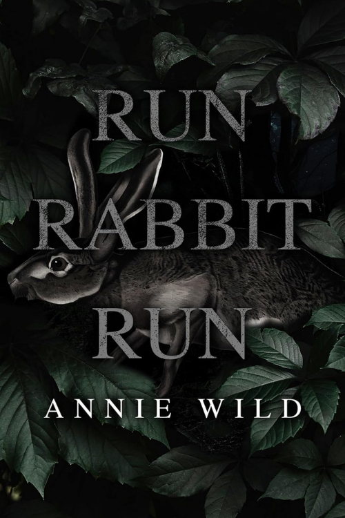 Book cover for 'Run Rabbit Run' by Annie Wild, featuring a dark background with green leaves and a rabbit lying on its side.