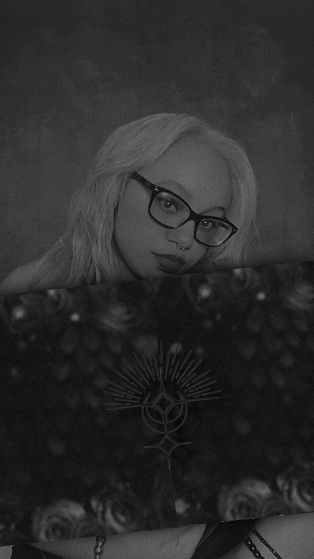 A black and white photograph of a woman with light hair, glasses, and a septum piercing, holding a box with a floral pattern and a geometric design.