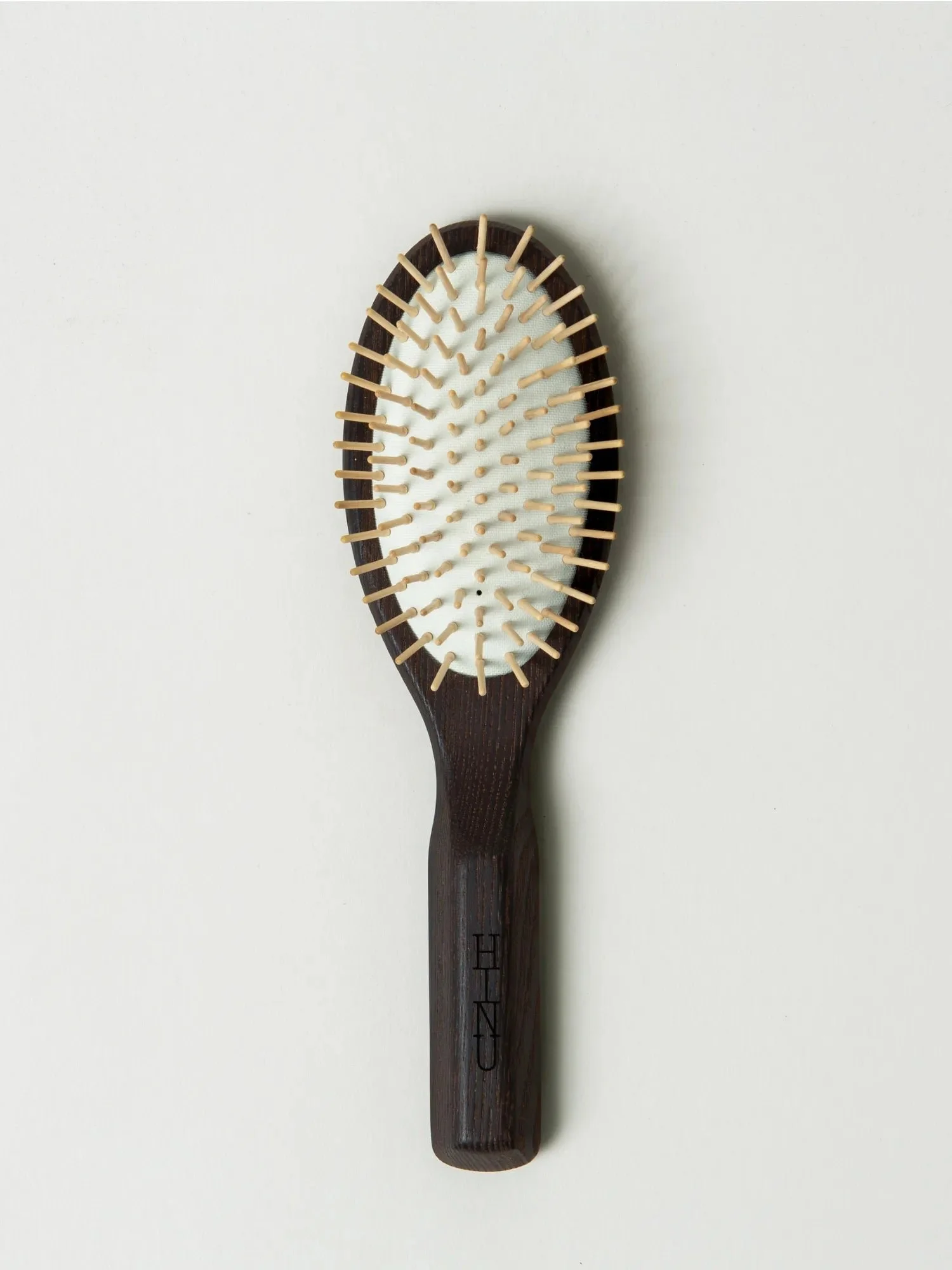 Wooden hair brush with cushioned bristle pad, on white