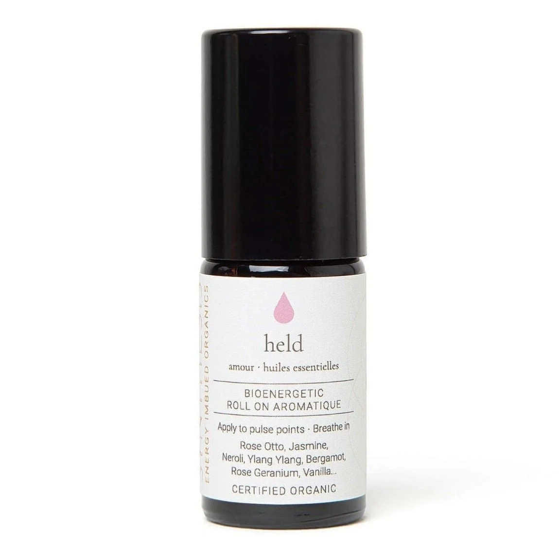 Held organic essential oil roll-on, dark glass bottle on white