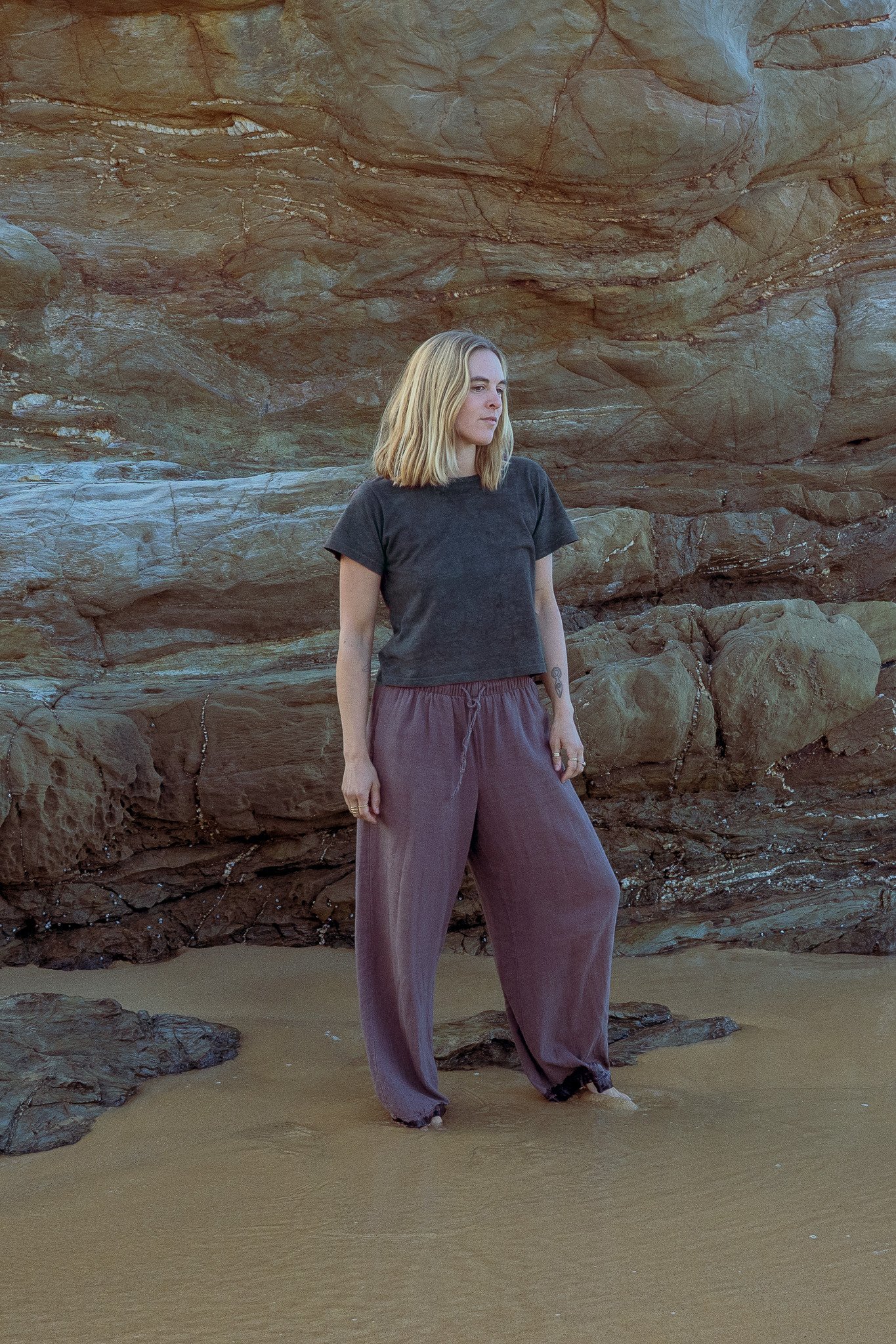 Women's cropped plant dyed hemp tee in dark indigo, worn on the beach
