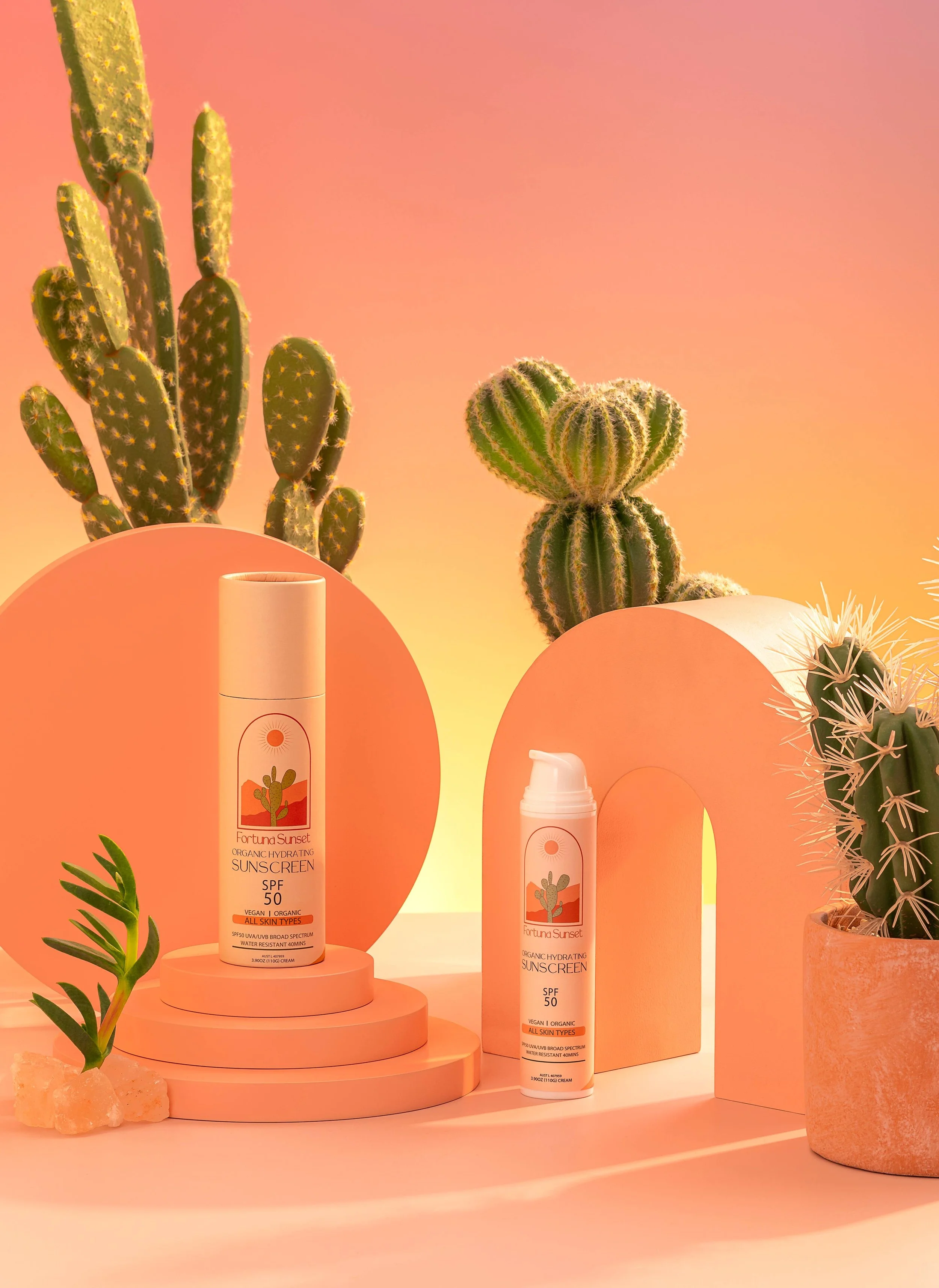 Organic zinc sunscreen SPF 50 bottles on a peach set with cactus plants