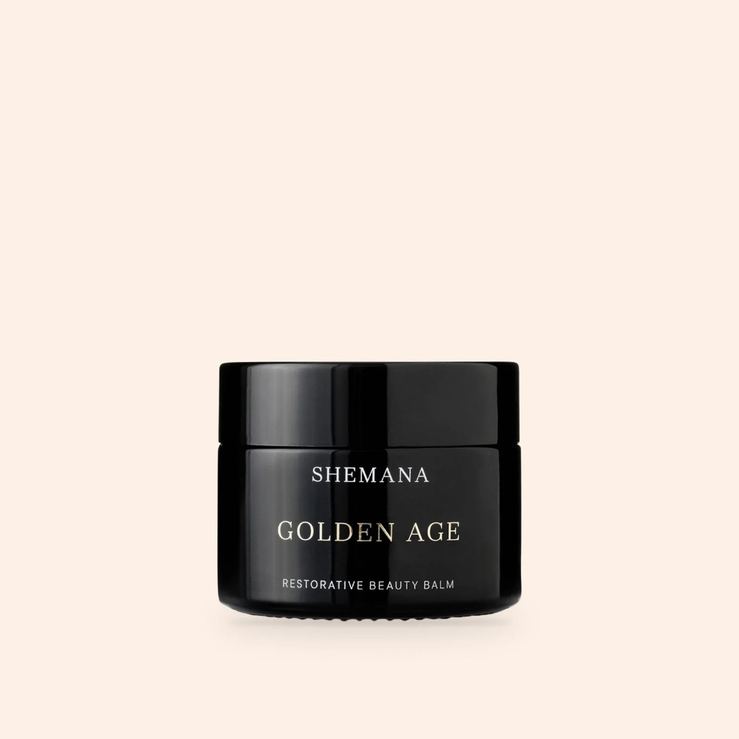 Golden Age Beauty Balm 50g, black glass jar on a peach background