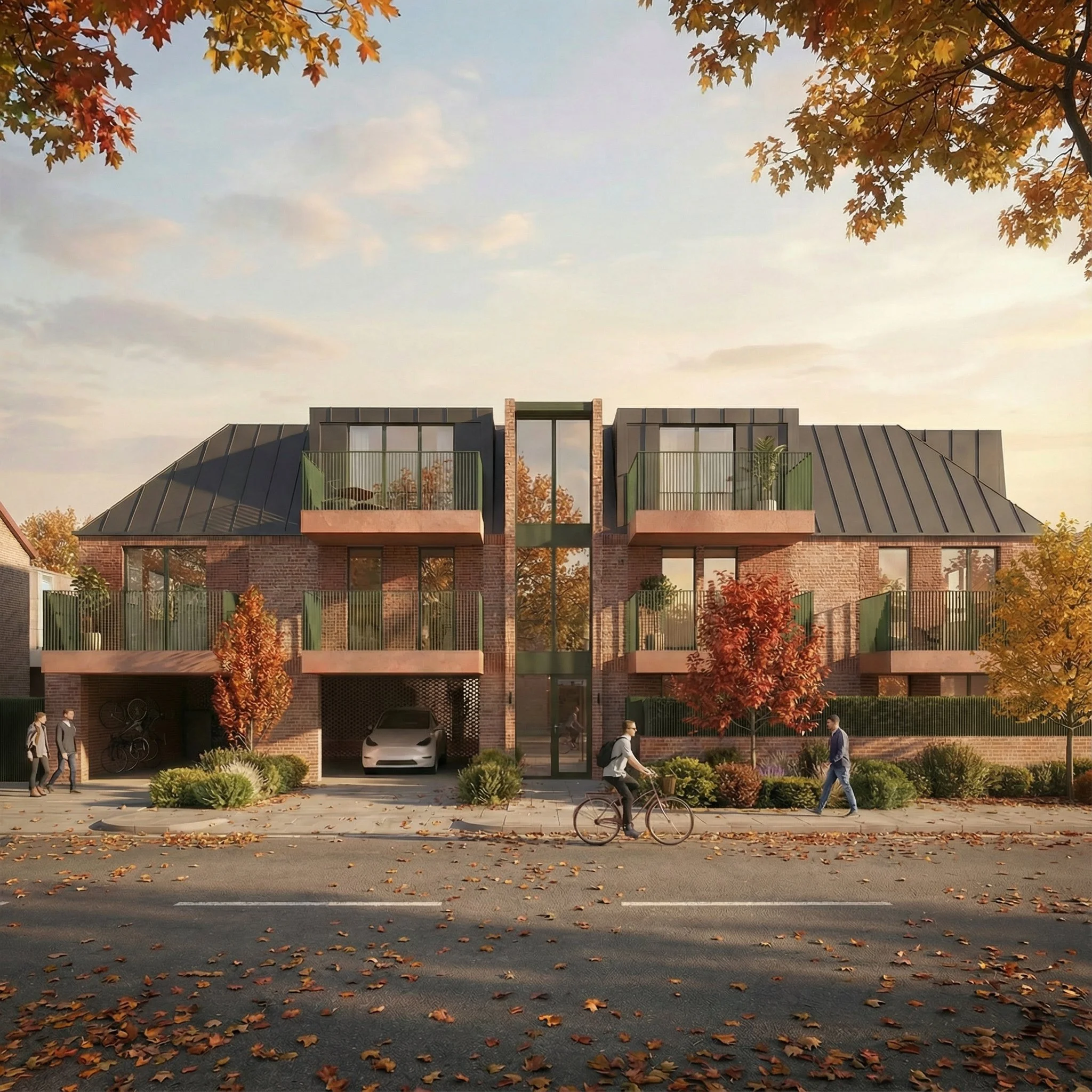 A modern, multi-story apartment building with brick exterior and green balconies, set amidst autumn trees with fallen leaves on the street and sidewalk in front.