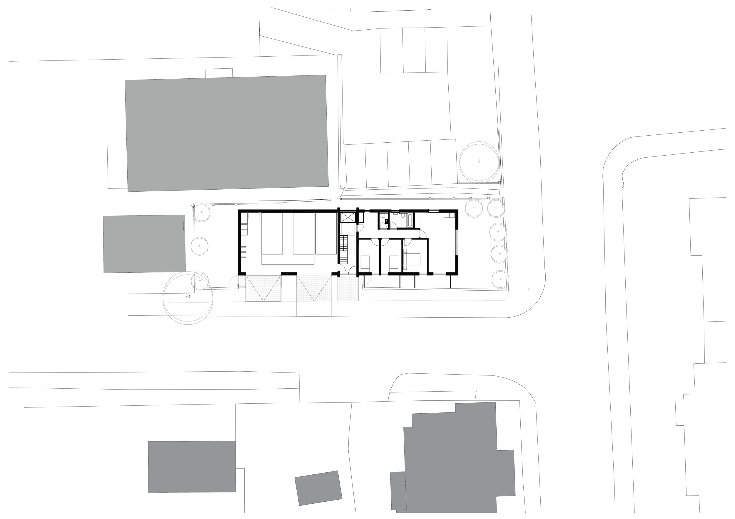 Architectural site plan showing a detailed building layout with surrounding trees and neighboring structures, in black and white.