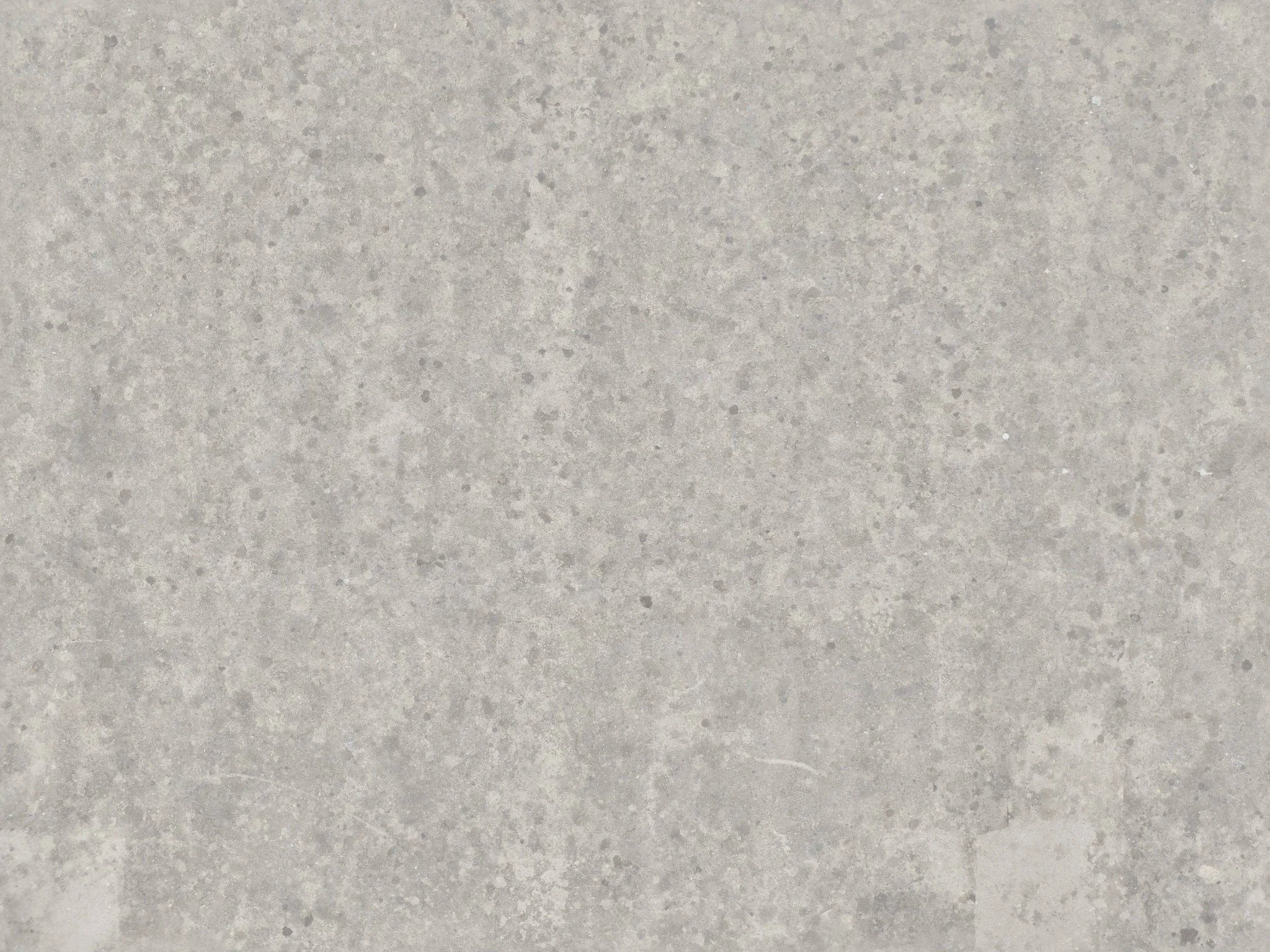 Gray concrete surface with small speckles and subtle texture variations.