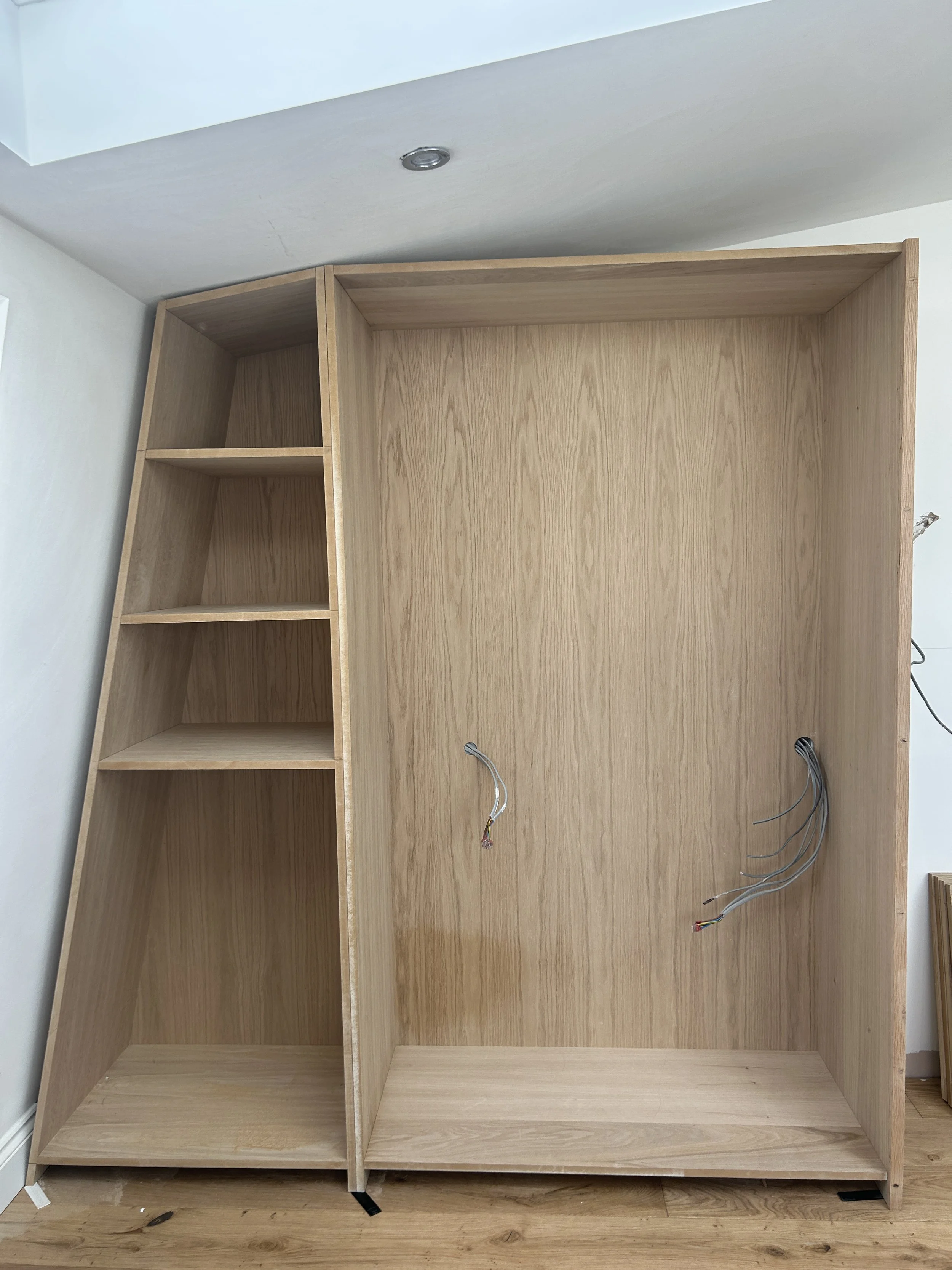 The left side includes a bespoke corner wardrobe storage unit, with three shelves and three drawers.