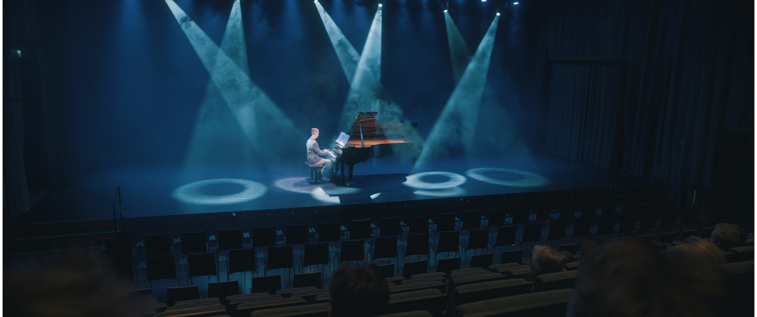 Pianisti esiintymässä teatterisalissa valojen loistaessa, Charles Smith - Koston Kyynel -elokuva, kuvakaappaus elokuvasta