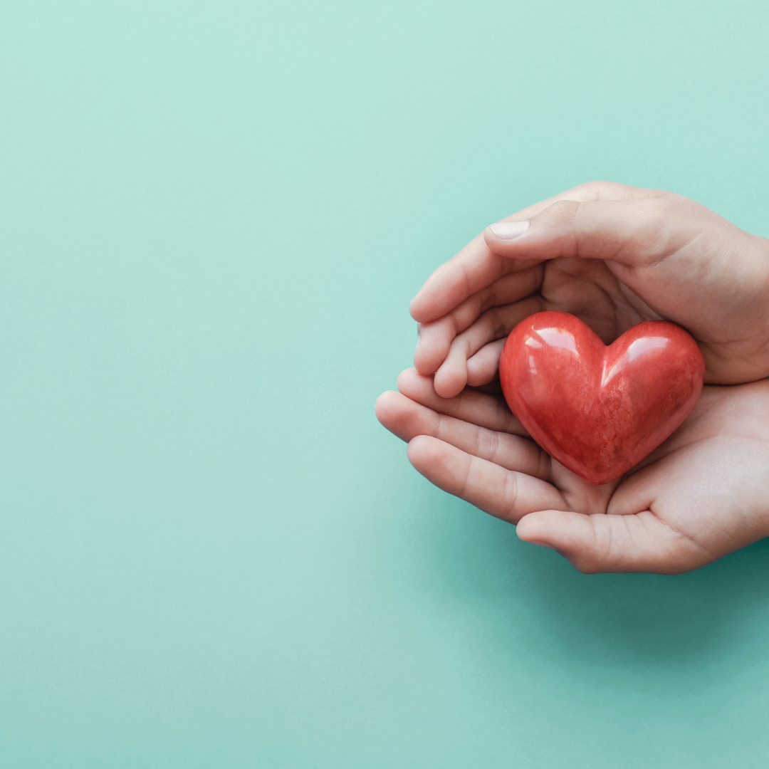 hand holding a small red heart