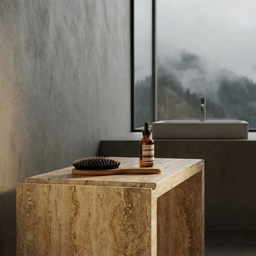 A bathroom with a stone countertop, a hairbrush, a dropper bottle, and a modern faucet by a large window with a foggy outdoor view.