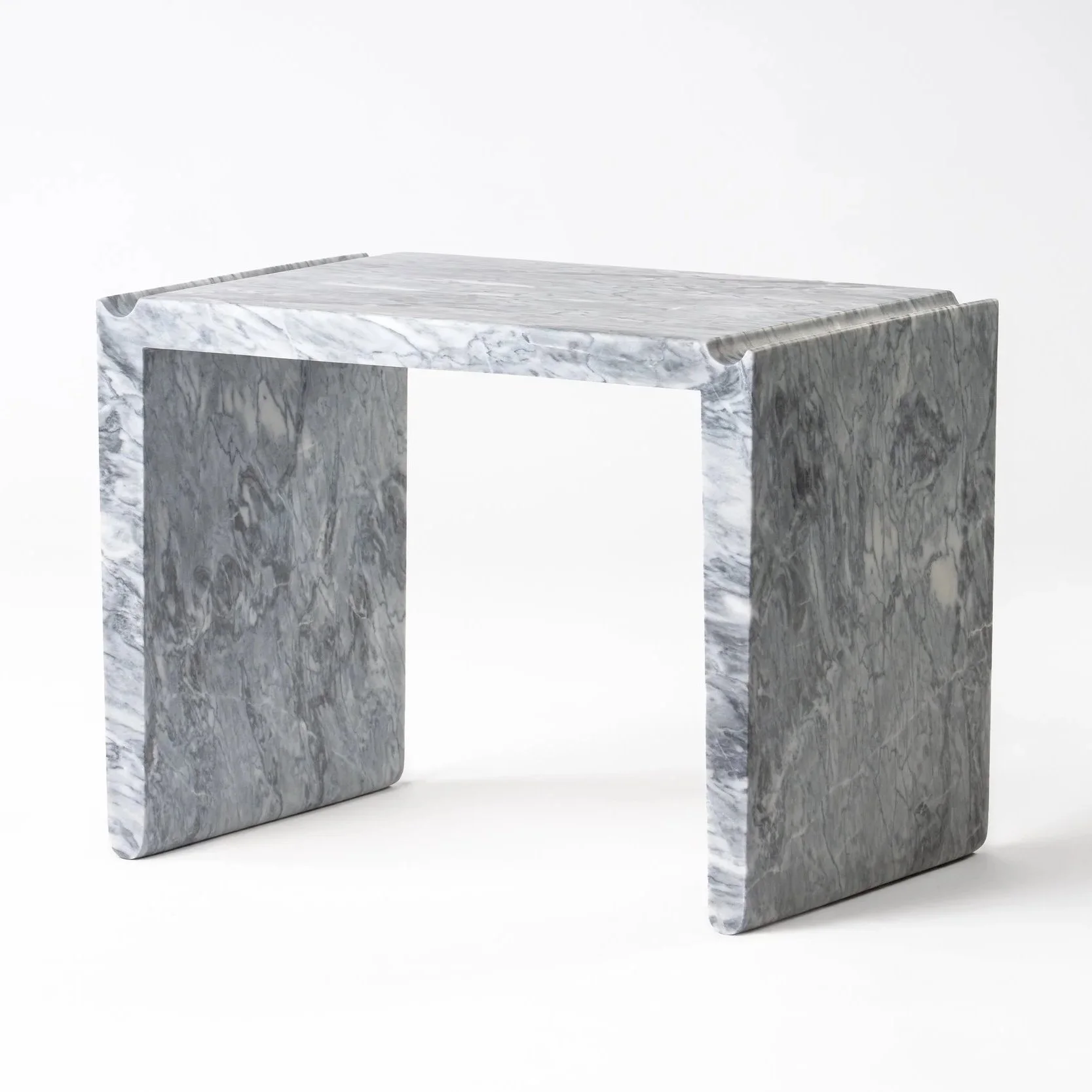 A modern marble fireplace with a rectangular opening and a clean, slab-like mantel.